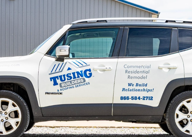 White Tusing Builders company vehicle parked in front of a facility, representing active support for commercial roof maintenance in Akron.