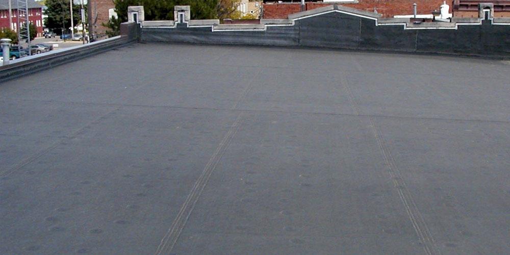 Flat commercial EPDM roof with high parapet walls and visible seams, showcasing professional Industrial Roofing in Youngstown OH solutions from Tusing Builders.