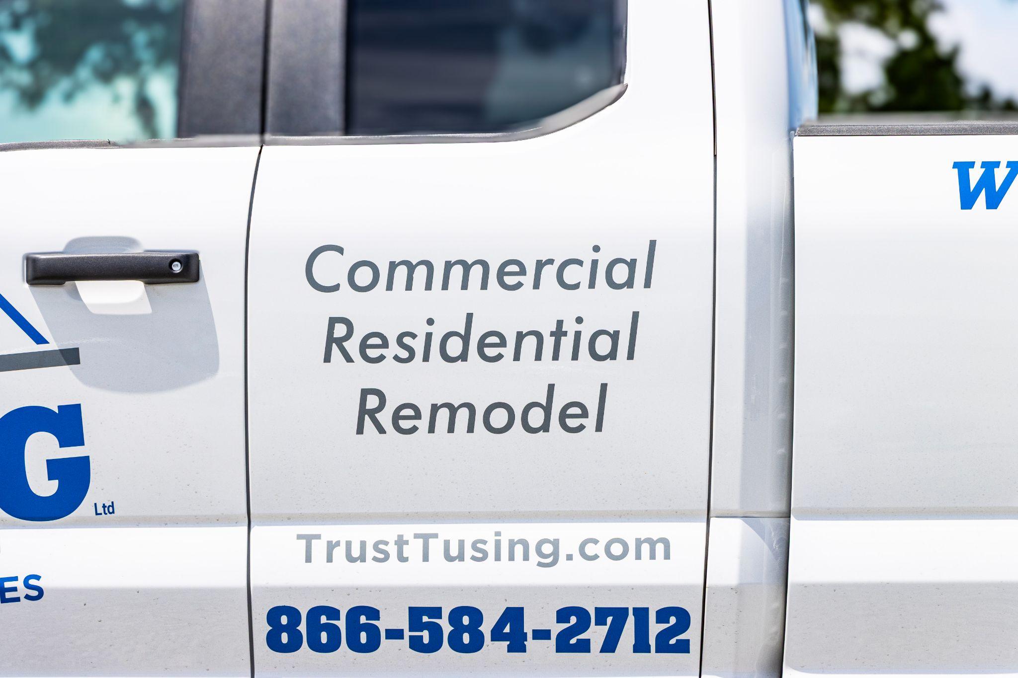Side view of a Tusing Builders service truck featuring company branding and contact information, providing professional support for Industrial Roofing in Youngstown OH.