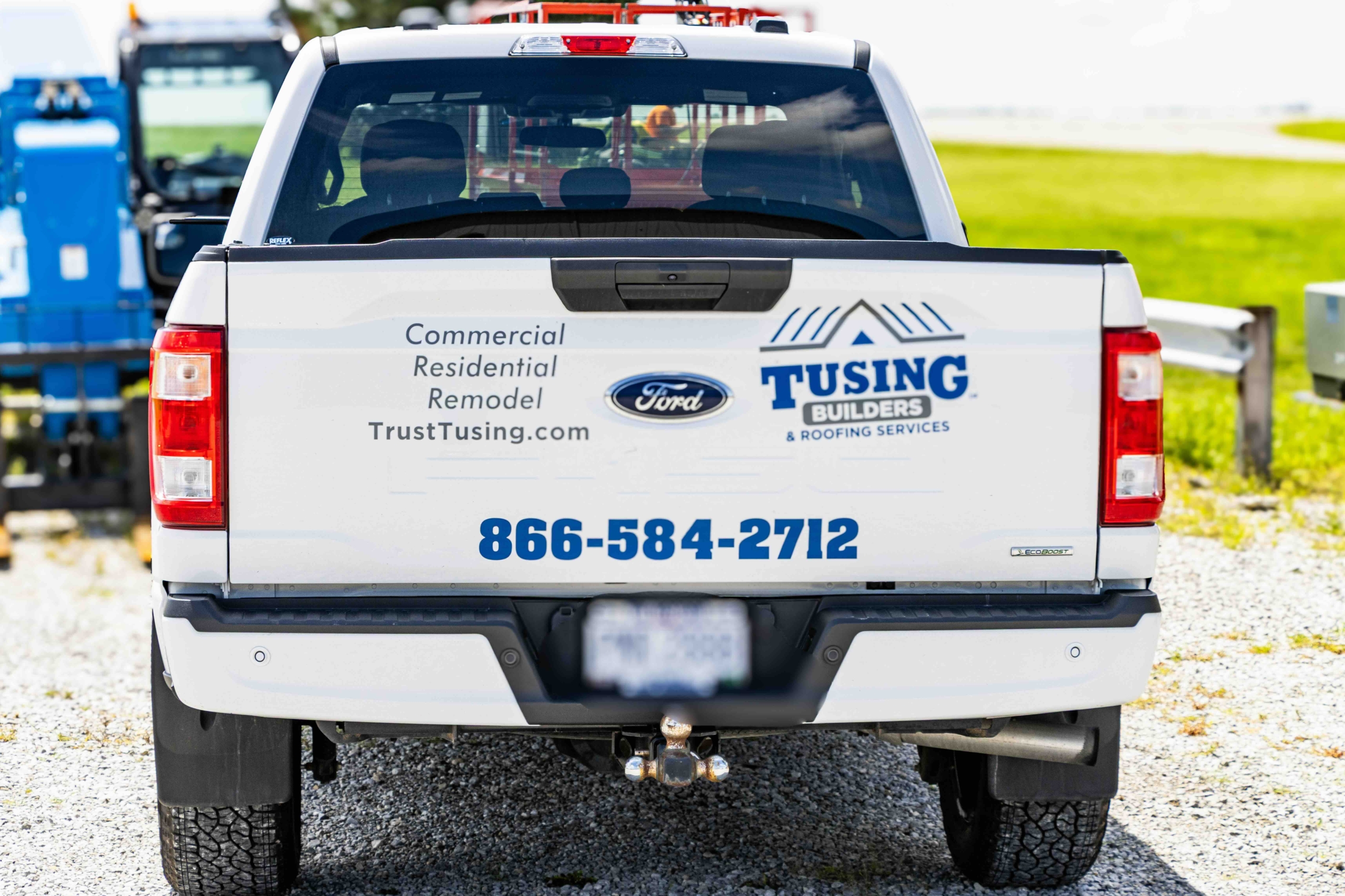 Tusing Builders & Roofing Services truck tailgate showing their contact information and status as a leading Ohio commercial roofing company, representing their mobile team of building science experts.